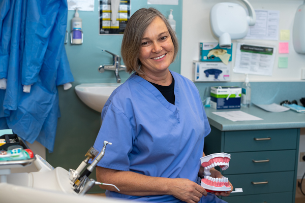 A dentist holding a set of false teeth