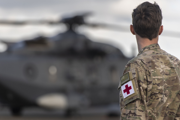 NZDF member viewed from behind, as they look at a helicopter